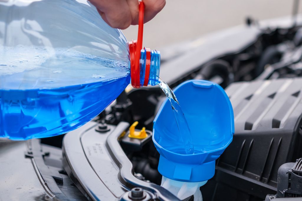 close-up-driver-pouring-blue-non-freezing-windshield.jpg