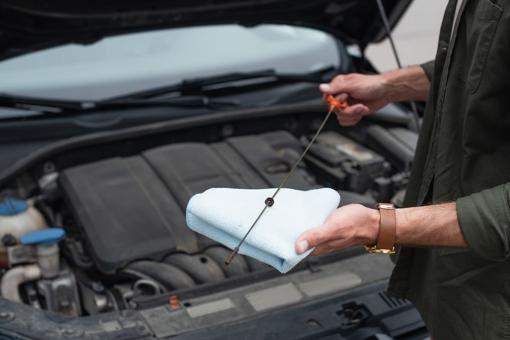 cropped-view-of-driver-holding-dipstick-and-rag.jpg