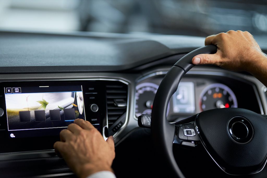 man-sitting-in-car-and-touching-digital-display.jpg