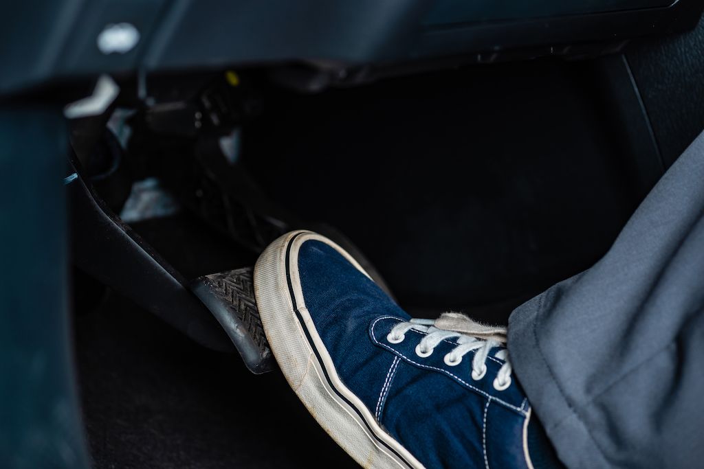 mechanic-in-sneakers-pressing-brake.jpg