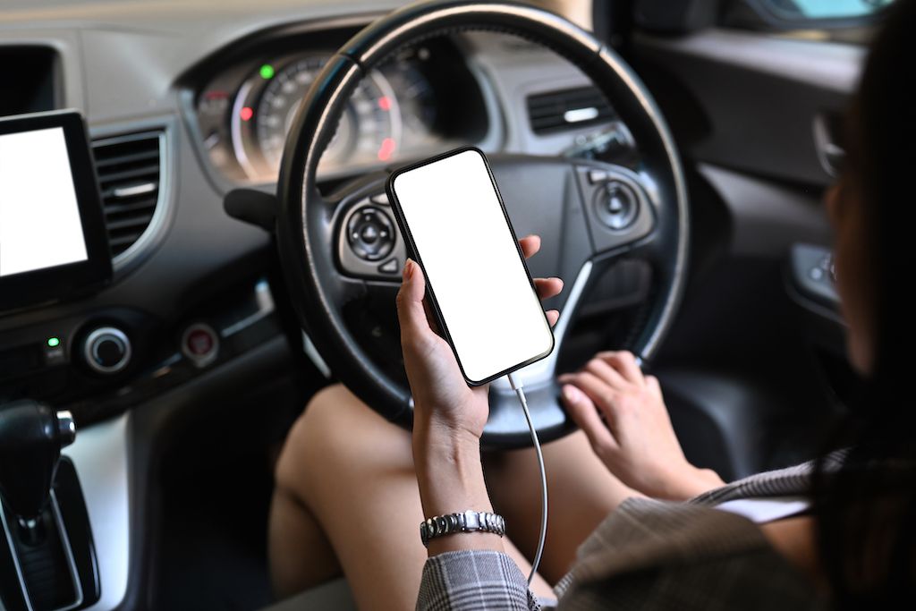 young-woman-using-smart-phone-texting-in-car.jpg